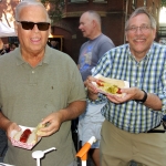 two men holding hot dogs