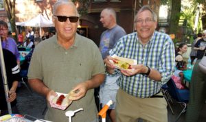 two men holding hot dogs