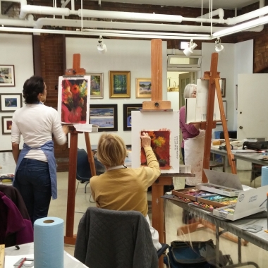 Two women painting in class