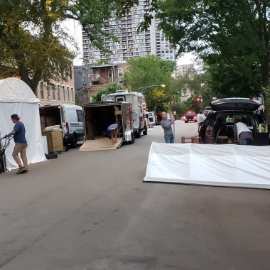 Trucks and people setting up tents